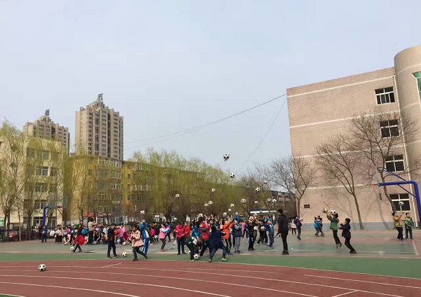 志愿者教授小学生们玩花样足球.jpg